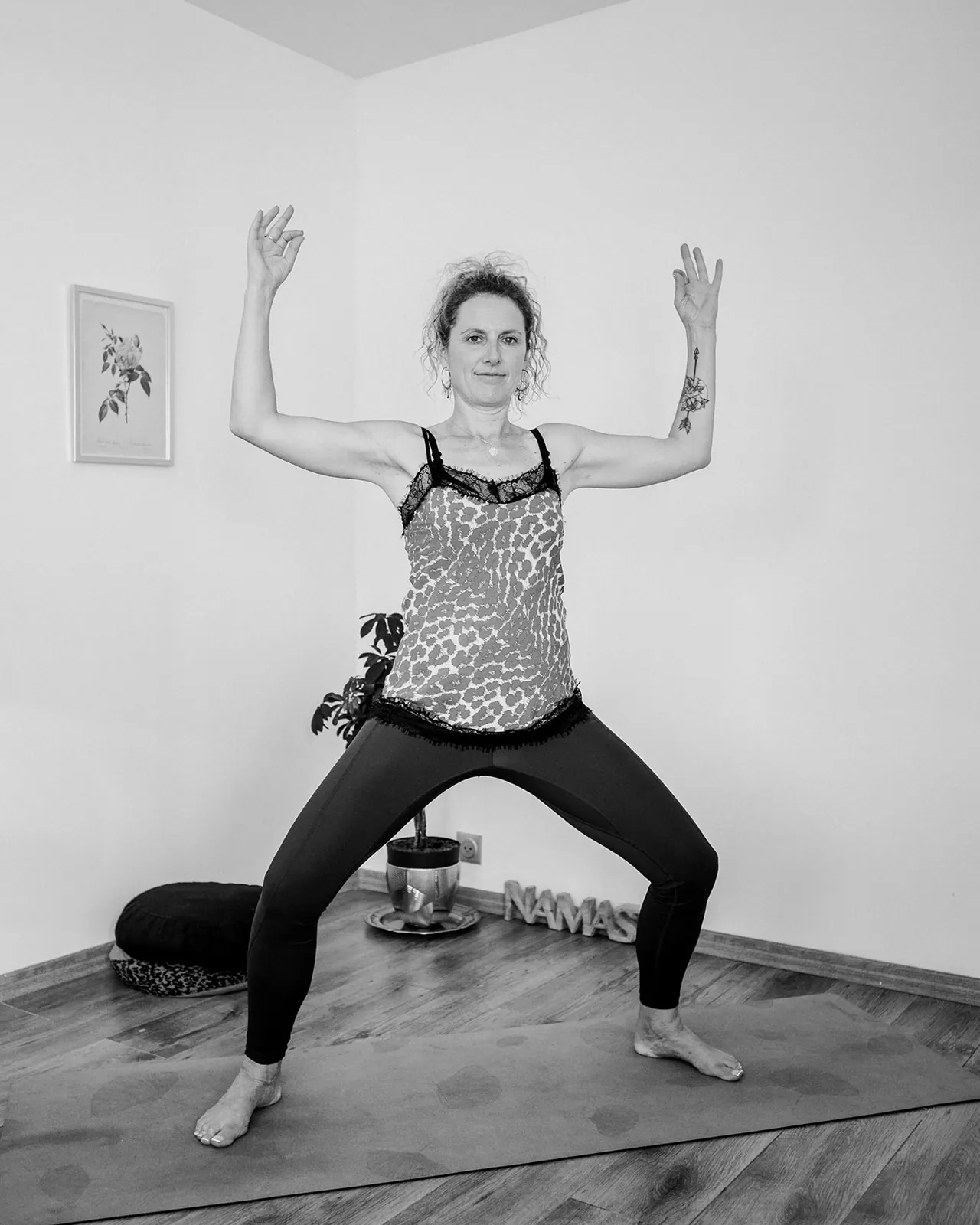 Julie Delpierre en posture de la déesse pendant un cours de yoga, noir et blanc